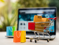 Image of a shopping trolley, shopping bags and a laptop